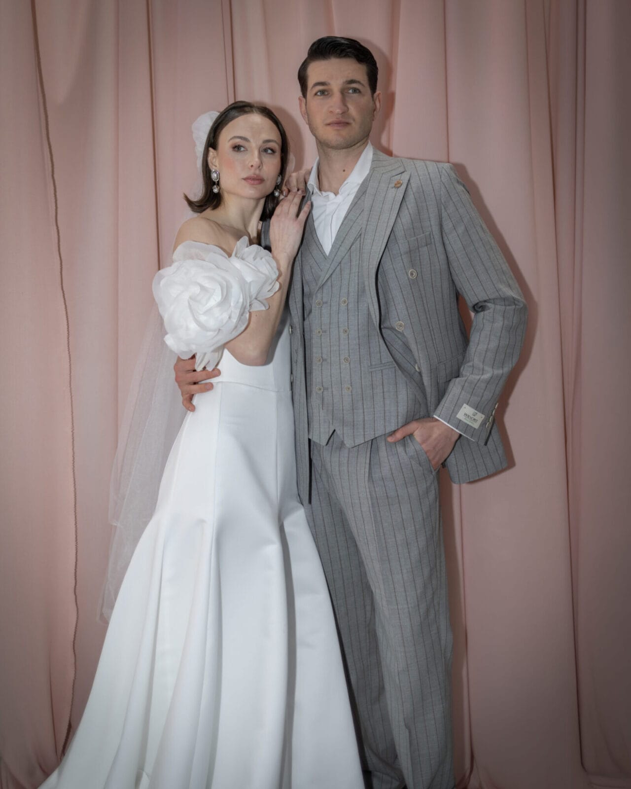 Elegantes Brautpaar beim Paarshooting vor rosa Hintergrund - Hochzeitsfotografie Münster von Kasha Wiesmann