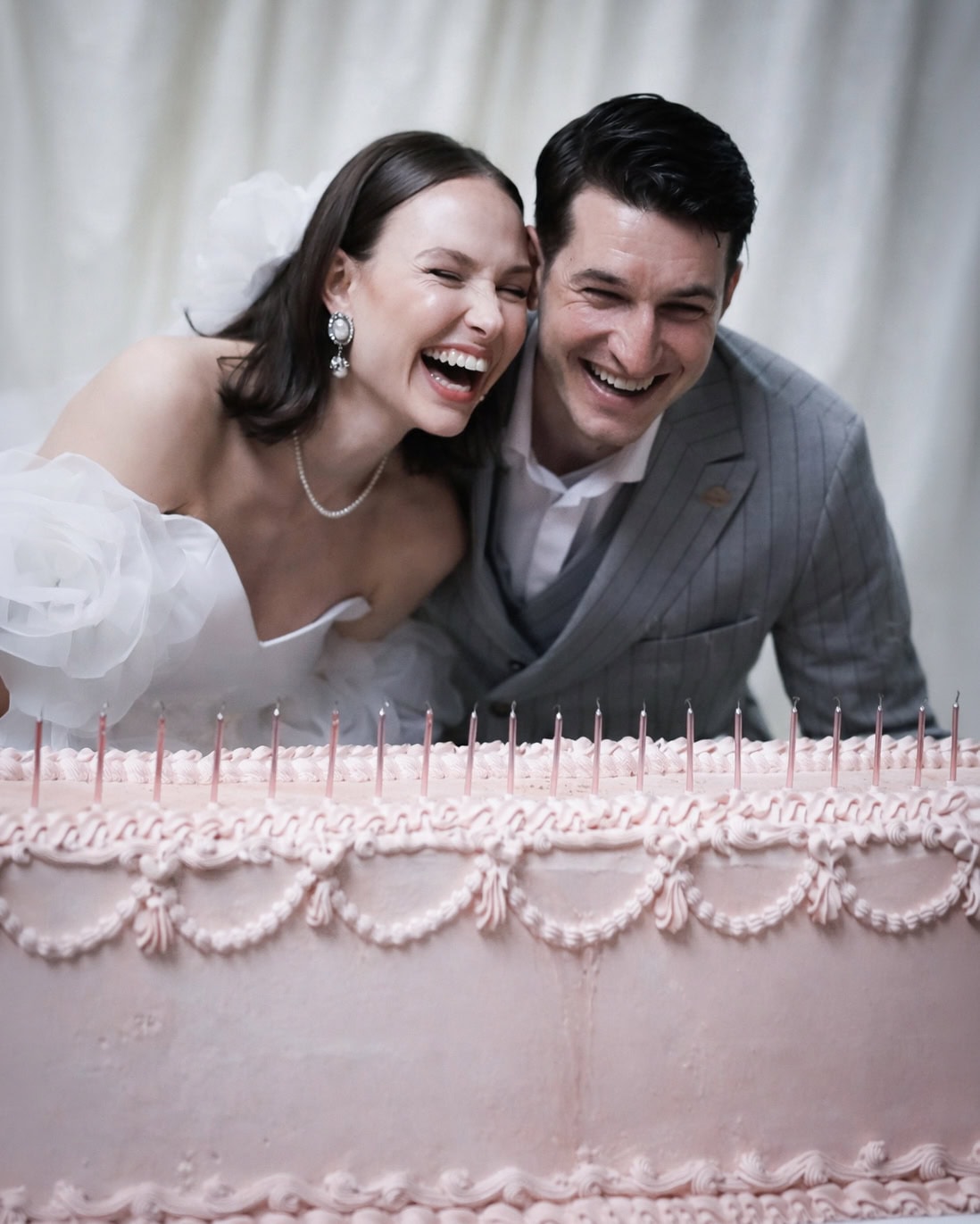 Brautpaar lacht ausgelassen vor der Hochzeitstorte - echte Freude bei der Hochzeitsreportage von Kasha Photography Warendorf