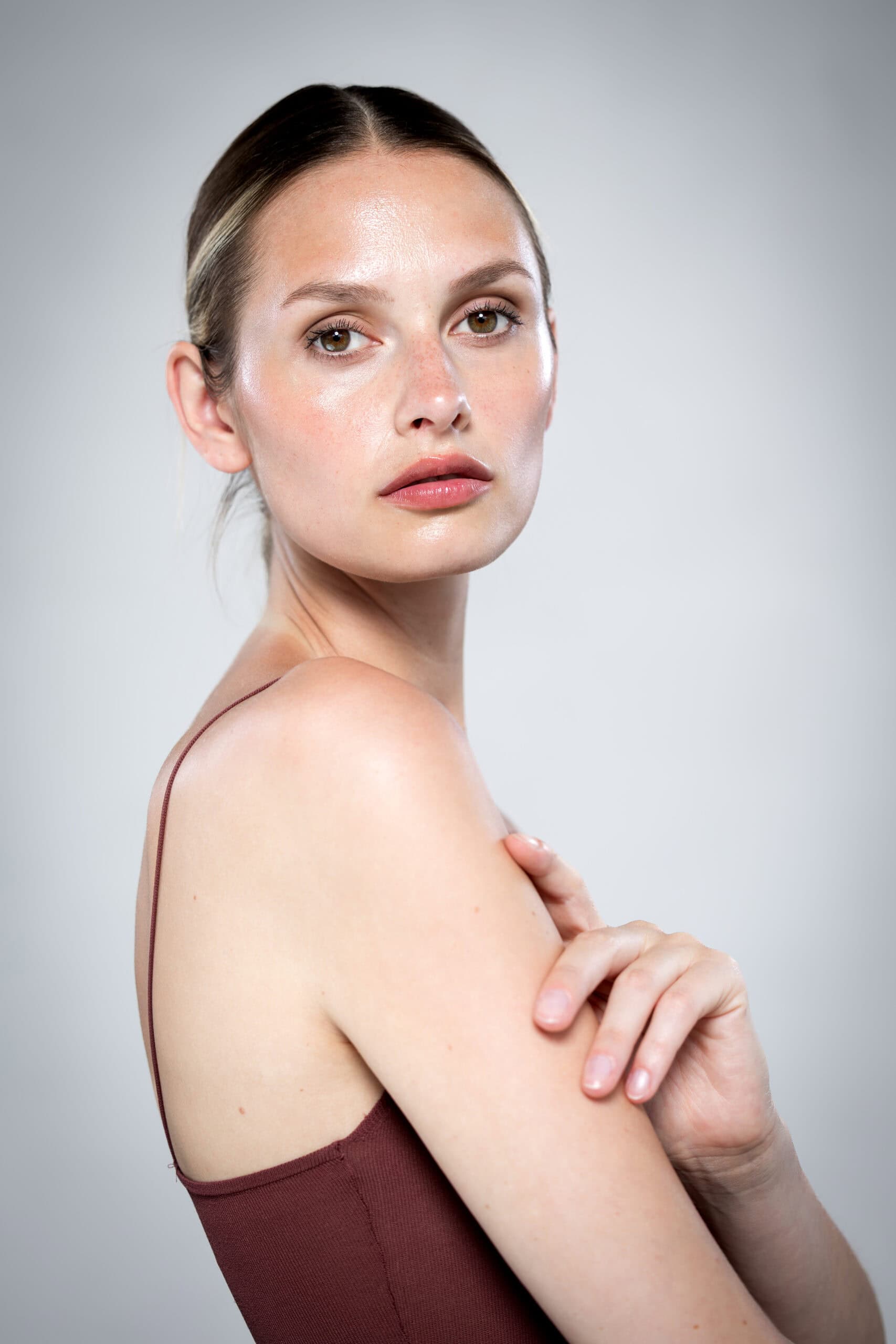 Branding Portrait Frau im burgunderfarbenen Top vor hellem Hintergrund